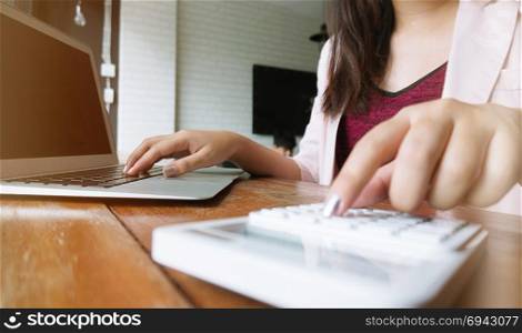 Accountant Working women use calculator with Spreadsheet document information financial concept.