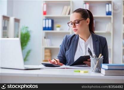 Accountantworking in the office with calculator. The accountantworking in the office with calculator