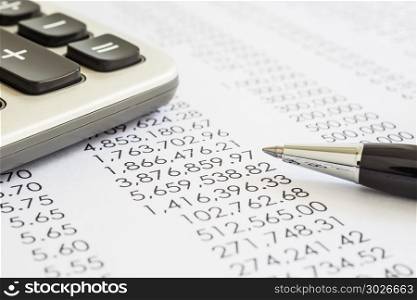 Accounting and audit evaluation of financial statements. . Closeup of financial statements, annual reports with modern pen and calculator in flame, black and white tone. Concepts of accounting, audit evaluation and business marketing.