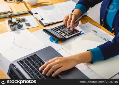 accounting concept. businesswoman working using calculator with money stack in office