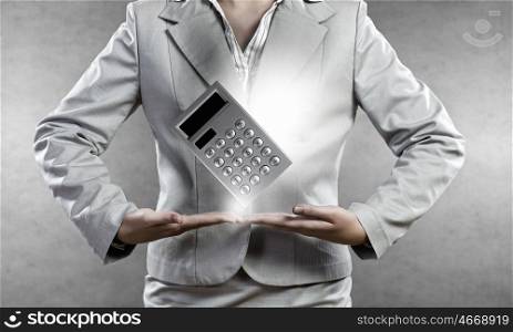 Accounting concept. Close up of businesswoman holding in hands calculator