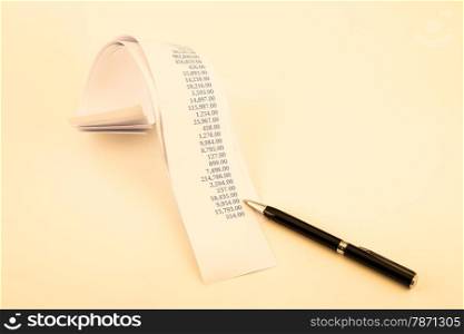 accounting concept with printout paper rolls and high quality pen in vintage retro style tone
