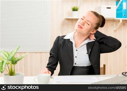 accounting employee by hand massages sick's neck while sitting at the office table