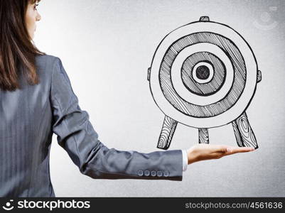 Achieving goals. Rear view of businesswoman pointing at drawn target