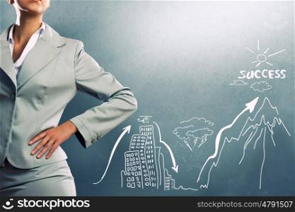 Achieving success. Close up of businesswoman and business sketches on cement wall