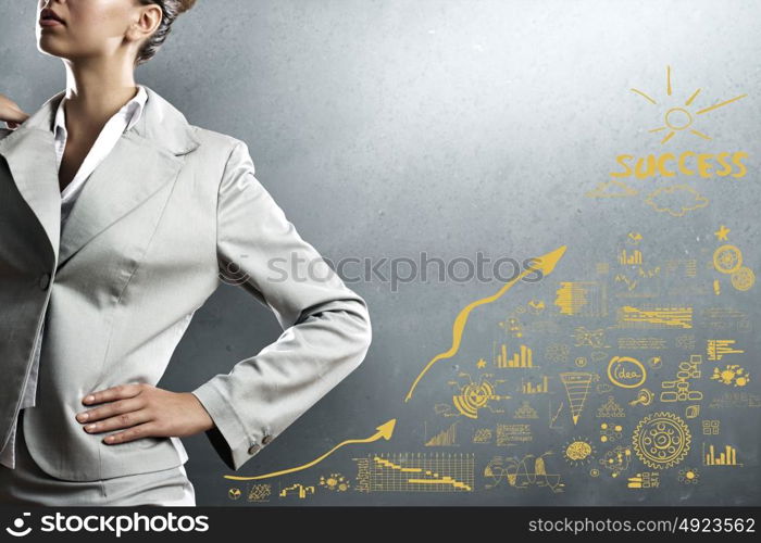 Achieving success. Close up of businesswoman and business sketches on cement wall