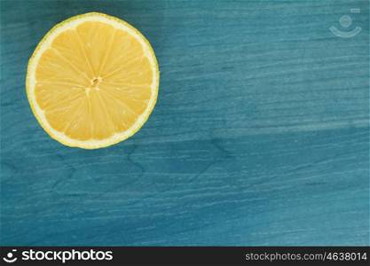 Acid and yellow fruit. Half lemon on a blue wood
