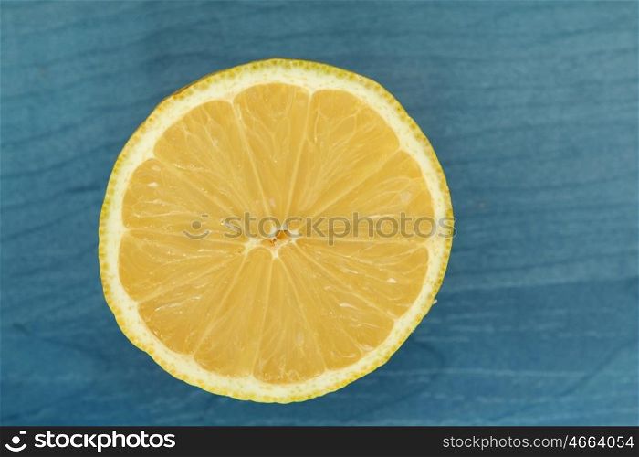 Acid and yellow fruit. Half lemon on a blue wood