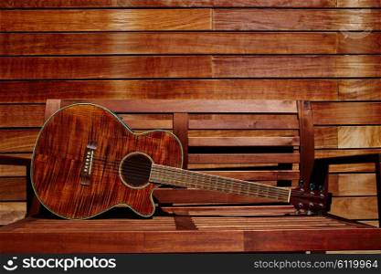 acoustic brown guitar in a wooden stripes wooden wall monochromatic