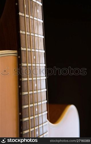 Acoustic guitar close-up over dark background