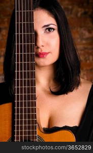 acoustic guitar performer against brick wall