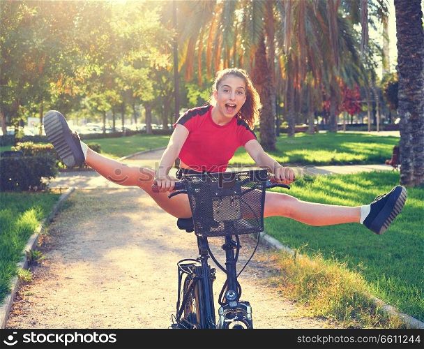 Acrobatic girl riding e-bike in a city park with red t-shirt foldable ebike