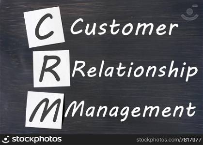 Acronym of CRM - Customer Relationship Management written on a blackboard