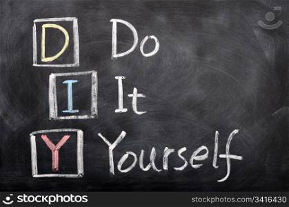 Acronym of DIY for Do It Yourself written with chalk on a blackboard