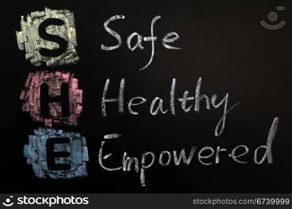 Acronym of SHE - Safe,Healthy and Empowered written on a blackboard