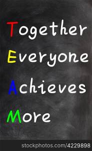 Acronym of TEAM for Together Everyone Achieves More on a blackboard background