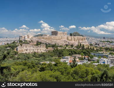 Acropolis and Lycabettus Hill framed by trees from the summit of Lycabettus hill. Panorama of city of Athens from Lycabettus hill