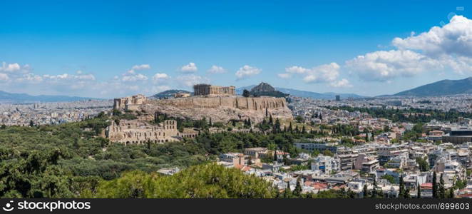 Acropolis and Lycabettus Hill framed by trees from the summit of Lycabettus hill. Panorama of city of Athens from Lycabettus hill