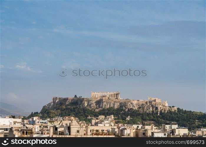 Acropolis hill with the city of Athens surrounding it. Acropolis hill rises above Athens apartments