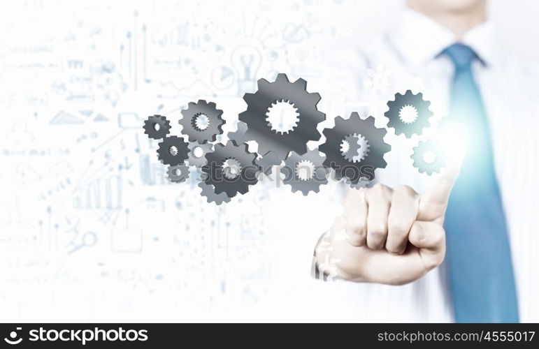 Activate working mechanism. Close up of businessman touching gears mechanism with finger