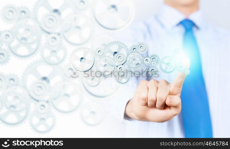 Activate working mechanism. Close up of businessman touching gears mechanism with finger