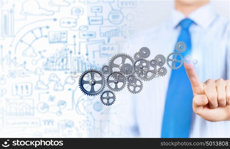 Activate working mechanism. Close up of businessman touching gears mechanism with finger
