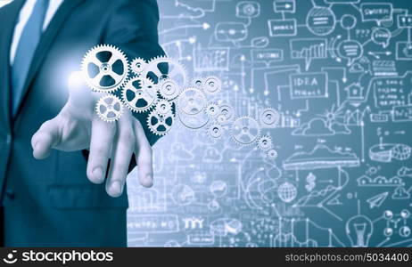 Activate working mechanism. Close up of businessman touching gears mechanism with finger