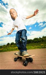Active childhood. Little man skateboarding. Skater boy child kid with his skateboard. Outdoor.