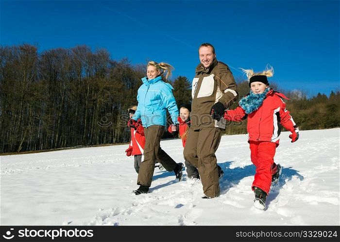 Active family having a winter walk in the snow