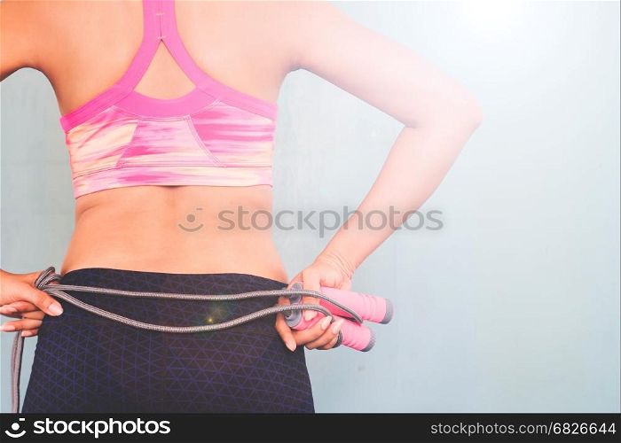 Active female in fitness clothing with jumping rope, Healthy and workout concept with copy space