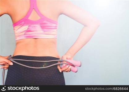 Active female in fitness clothing with jumping rope, Healthy and workout concept with copy space