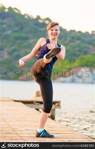 Active girl goes in for sports near the sea in the morning