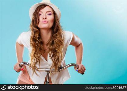 Active happy woman riding bike bicycle. Young girl in hat, white shirt and shorts. Healthy lifestyle and recreation leisure activity. Studio shot.