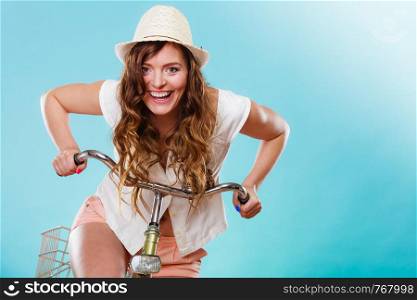 Active happy woman riding bike bicycle. Young girl in hat, white shirt and shorts. Healthy lifestyle and recreation leisure activity. Studio shot.. Active woman riding bike bicycle. Recreation.