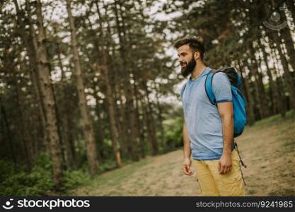 Active healthy man hiking in beautiful forest at summer day