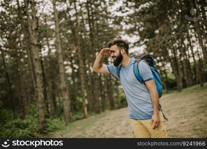 Active healthy man hiking in beautiful forest at summer day