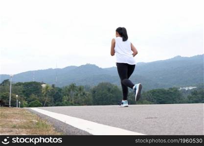Active healthy woman tying running shoes, jogging runner healthcare and well being concept