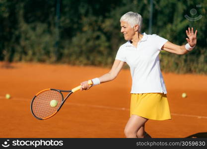 Active Lifestyle Seniors ? Positive Mature Woman Playing Tennis Recreationally