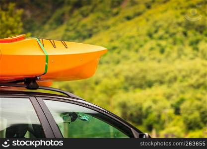 Active lifestyle sport concept. Car with kayak yellow canoe on top roof ready to transportation. Car with canoes on top