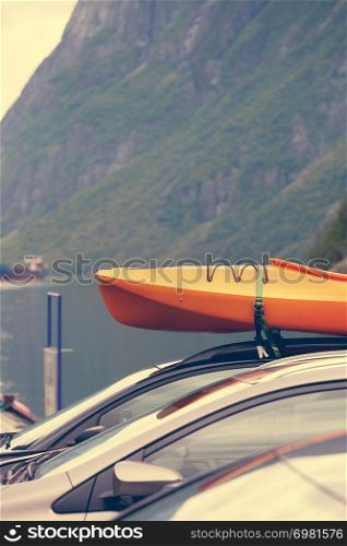 Active lifestyle sport concept. Car with kayak yellow canoe on top roof ready to transportation. Car with canoes on top
