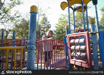 Active little girl running in the outdoor playground in the park. Happy child girl having fun on children playground. Play is learning in childhood.