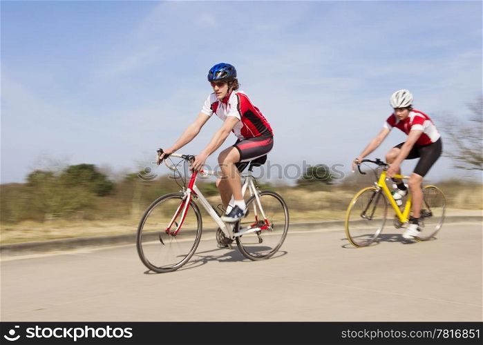 Active male athlete riding bicycles on an open country road
