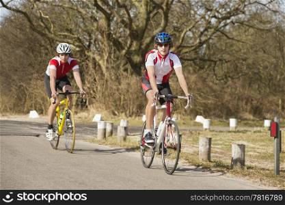 Active male athletes riding bicycles on a country road