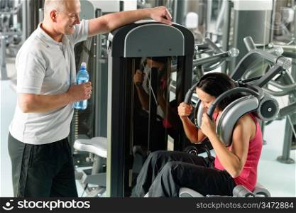 Active man and woman at fitness center exercise abdominal machine