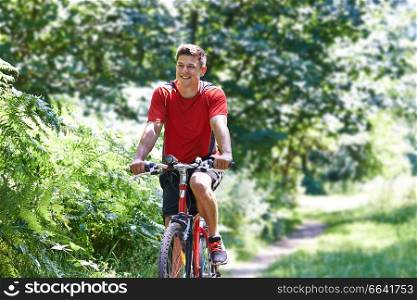 Active Man Cycling Along Path In Countryside