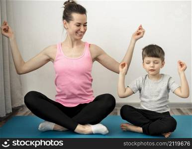 active mother practicing yoga with her son