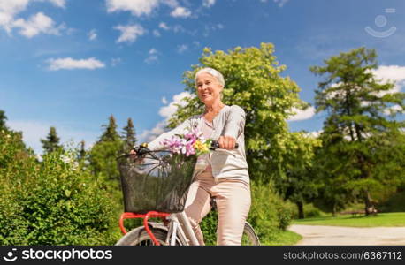 active old age, people and lifestyle concept - happy senior woman riding fixie bicycle at summer park. happy senior woman riding bicycle at summer park