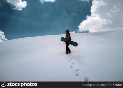 Active people enjoying the snow. Sports life and leisure. Snowboarder tourist girl walking on the mountain top. Ski park resort. Winter holidays and seasonal vacation travel.. Girl snowboarder enjoys winter sport