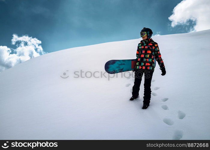 Active people enjoying the snow. Sports life and leisure. Snowboarder tourist girl walking on the mountain top. Ski park resort. Winter holidays and seasonal vacation travel.. Girl snowboarder enjoys winter sport