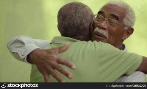 Active retired old men and leisure, two senior black brothers talking and hugging in park. Sequence